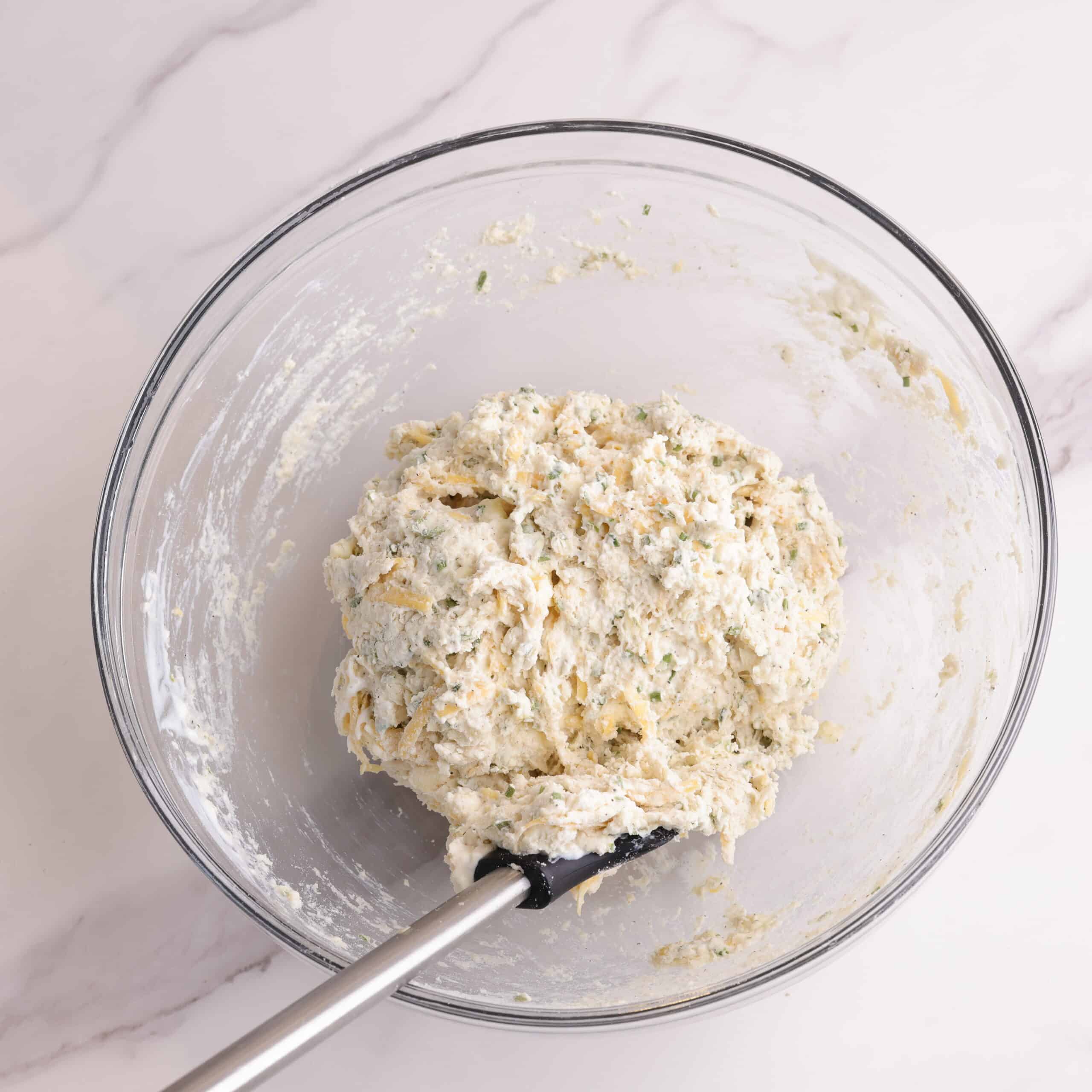 The dried ingredients from the picture above have now had the milk added a mixed together forming a ball of dough in the bowl with a spatula.