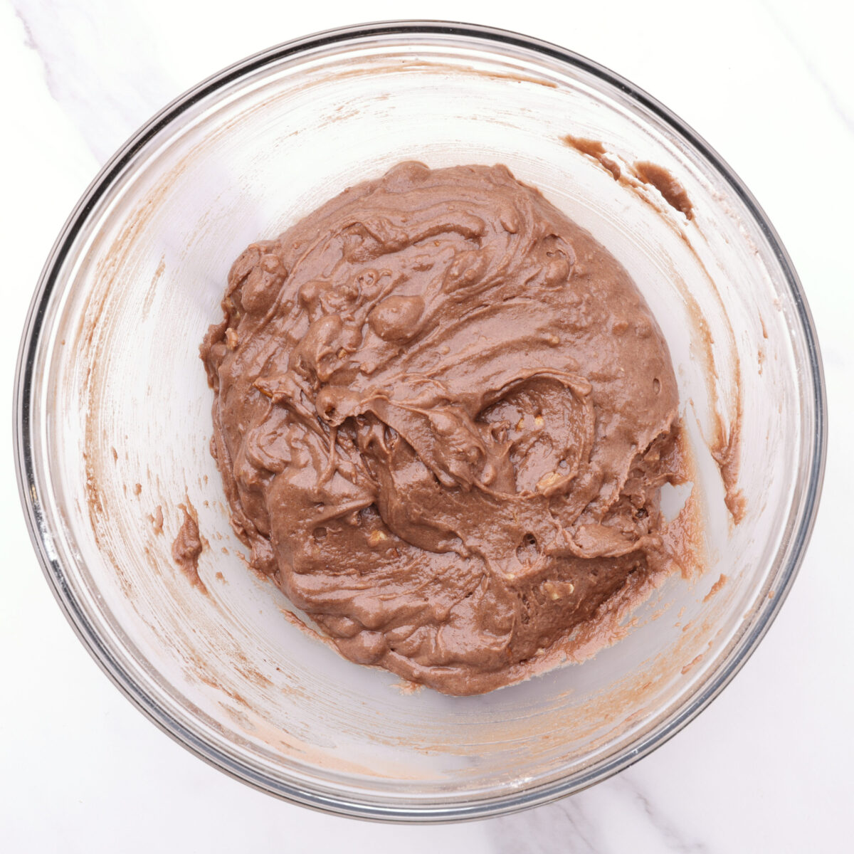 A bowl with the dry and liquid ingredients mixed together to form a chocolatey batter.