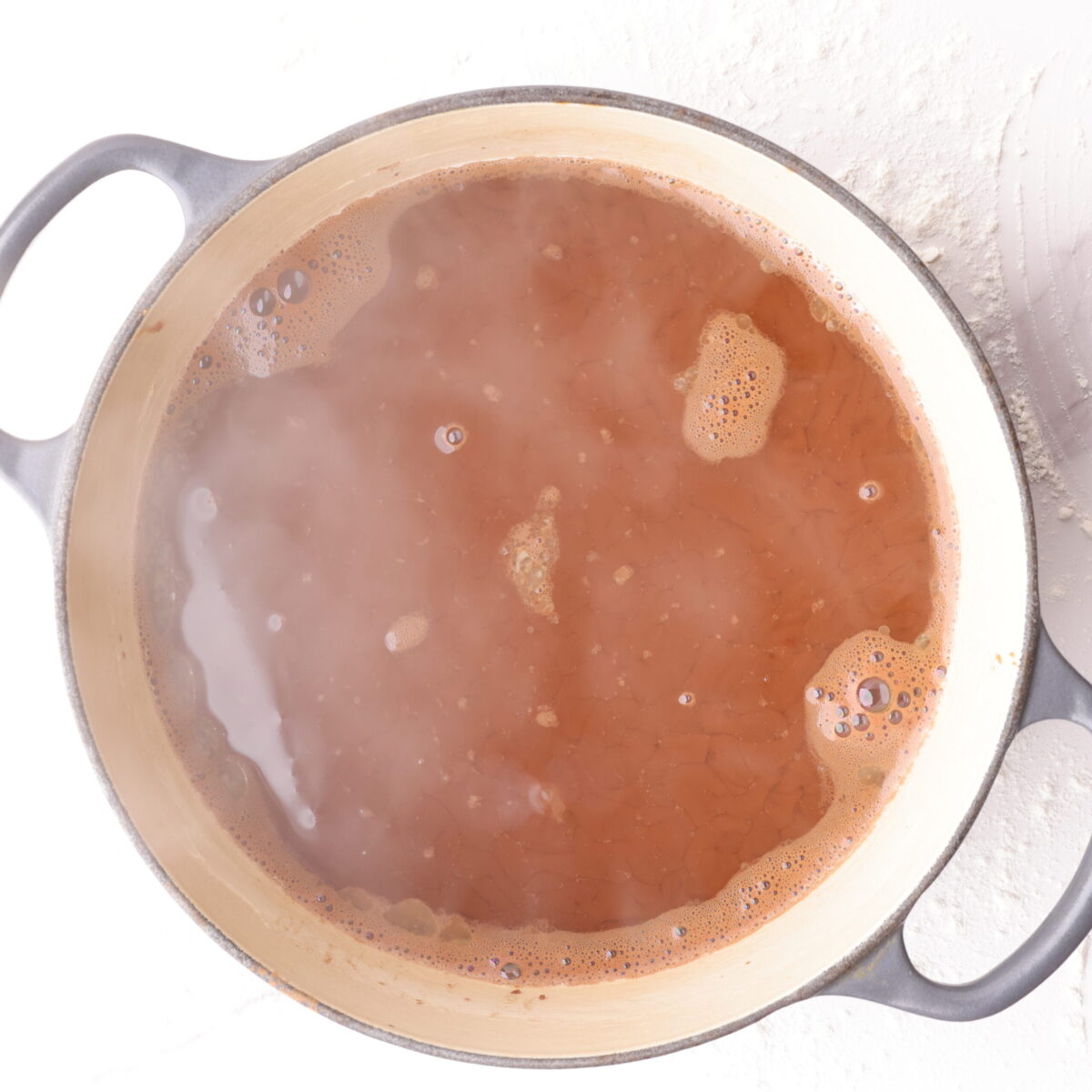 Hot water over mixed batter and topping in cast iron pot.