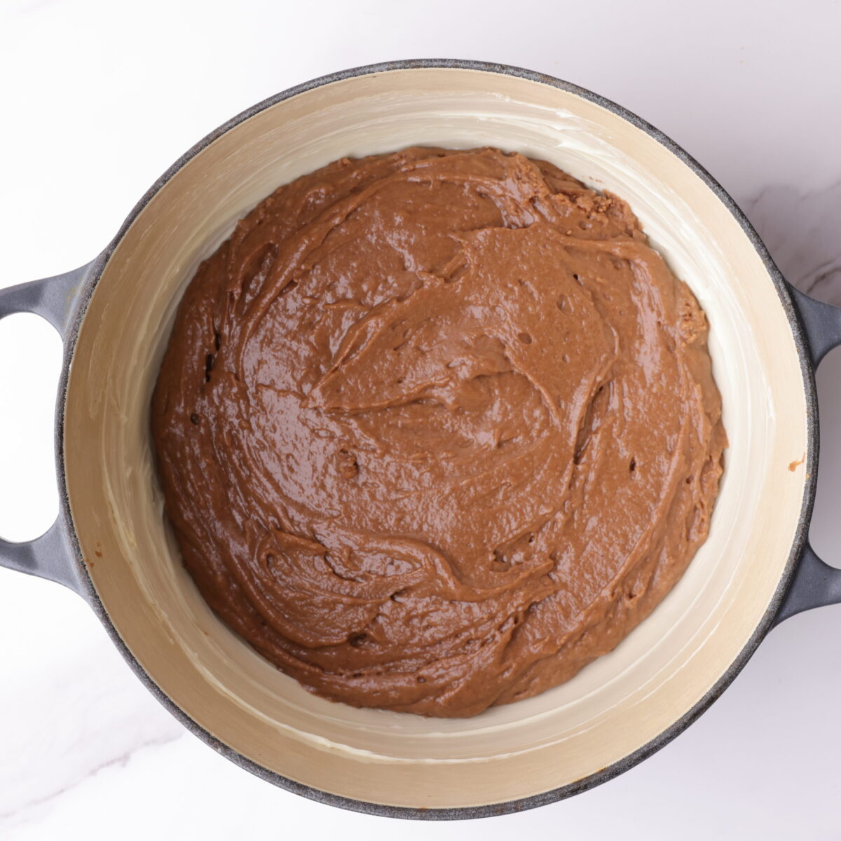 The mixed batter spread evenly in a buttered enameled cast iron pot.