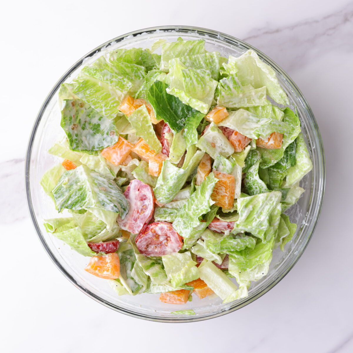 A bowl of the salad dressed and mixed with the chicken still omitted.