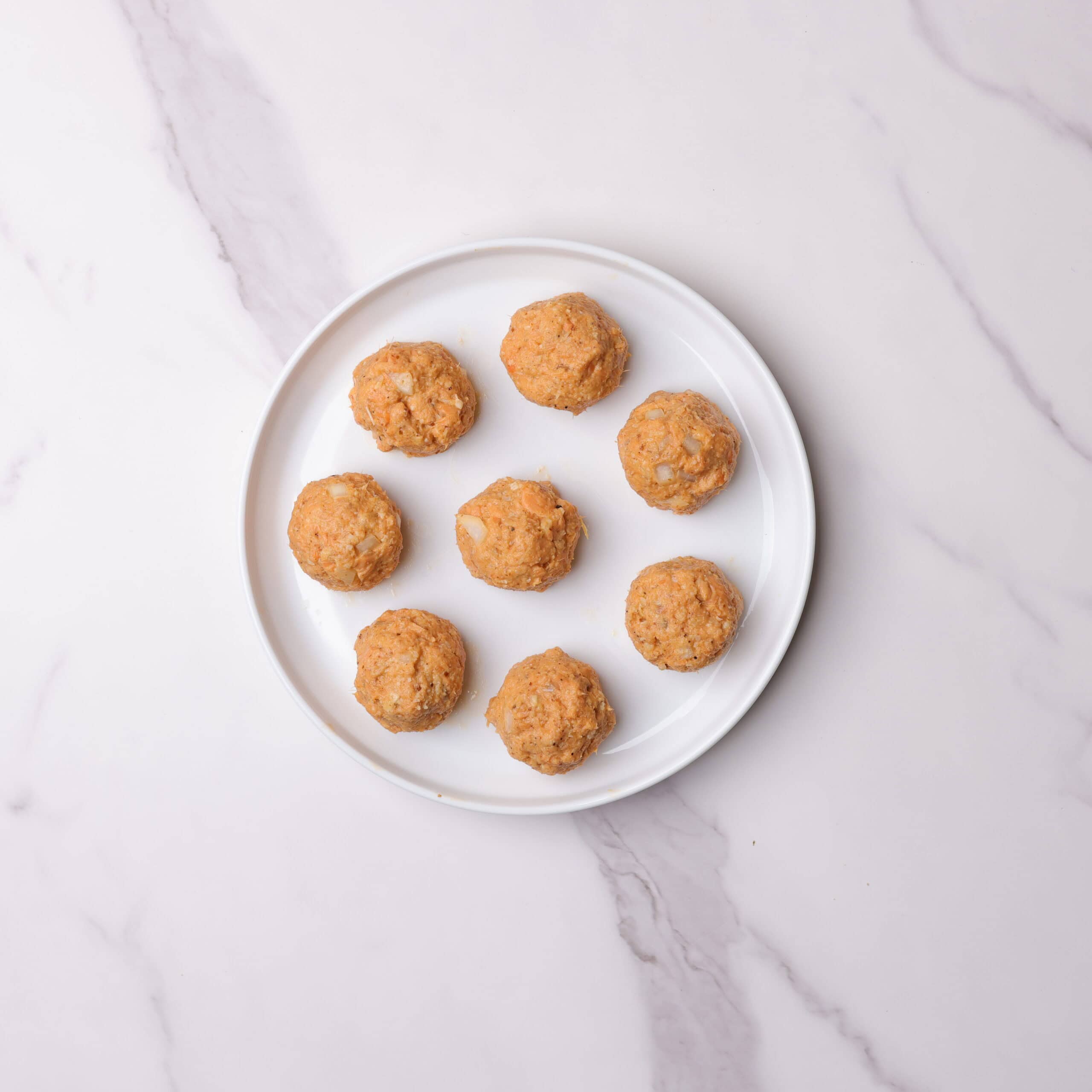A round plate with 8, round formed salmon meatballs.