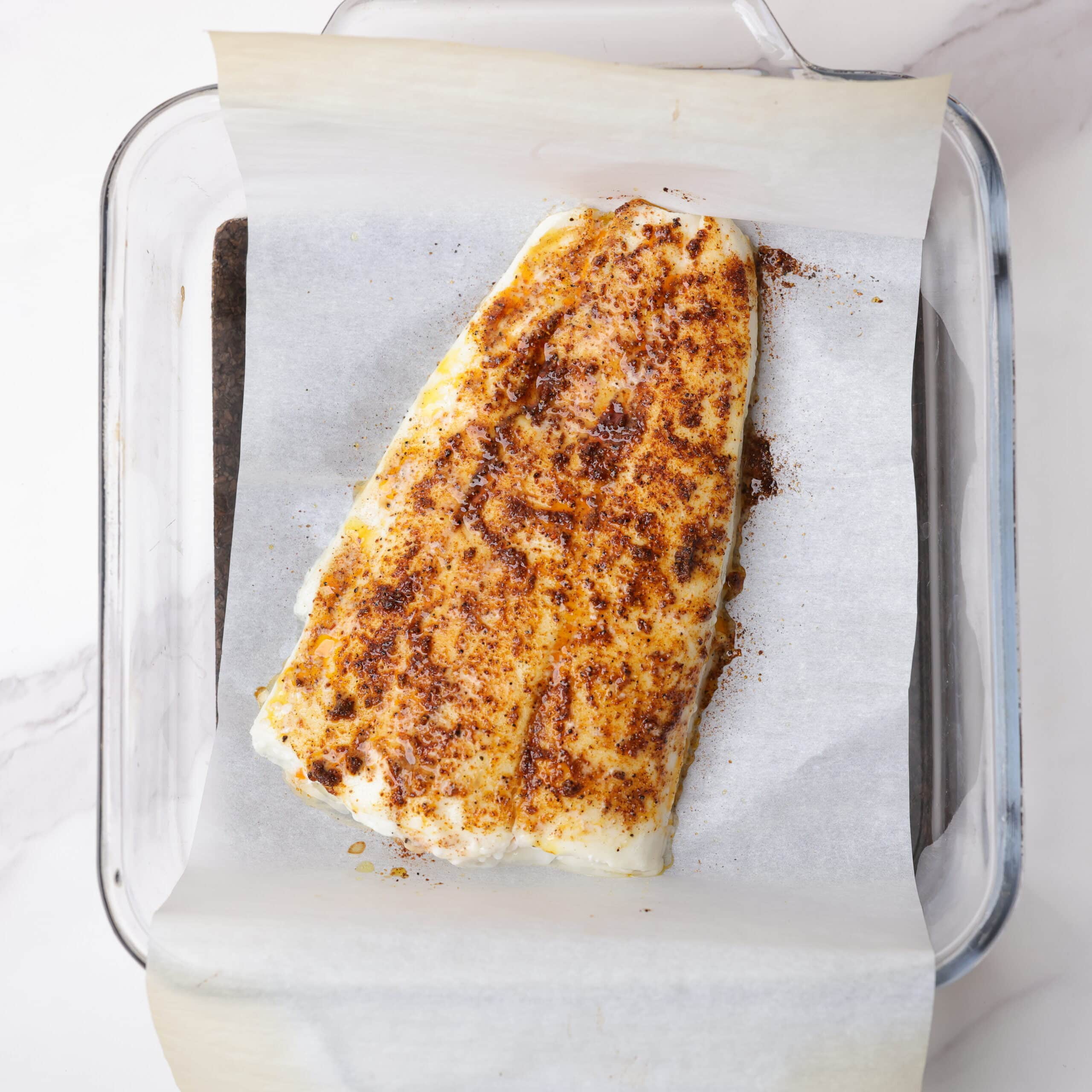 A baked fillet of seasoned halibut.