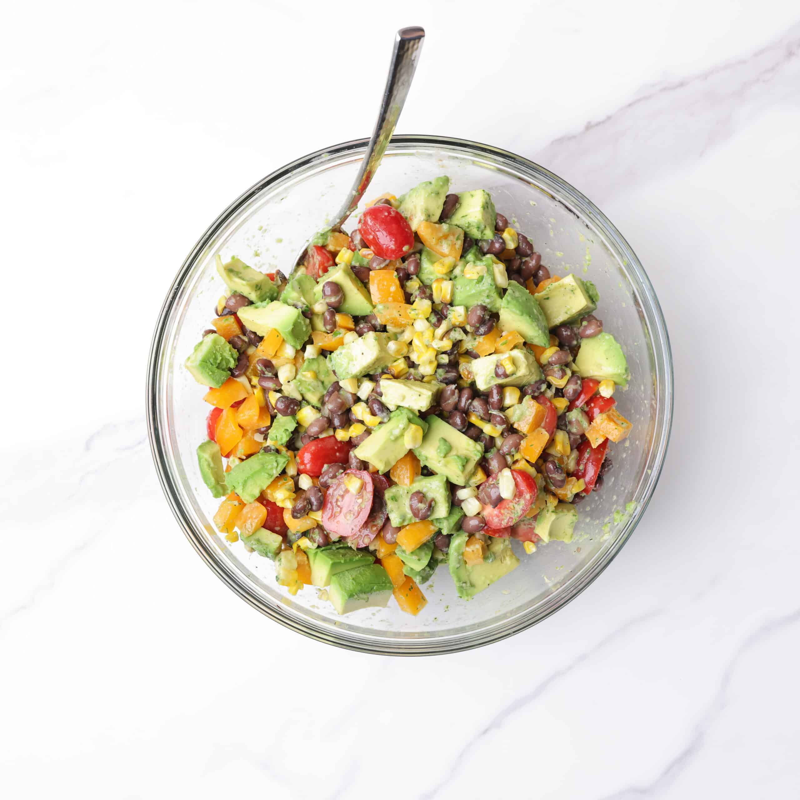 A large glass bowl containing all the ingredients for the salad prior to putting the dressing on it.