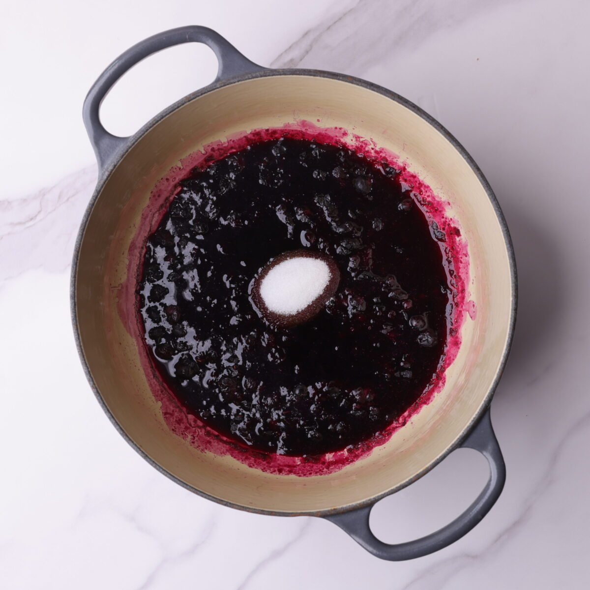A small pot with the cooked blueberries and the balsamic vinegar and sugar added. 