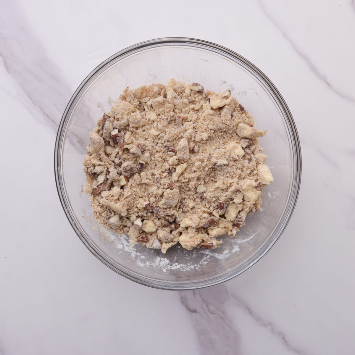 A glass bowl with the mixed crumb topping in it.
