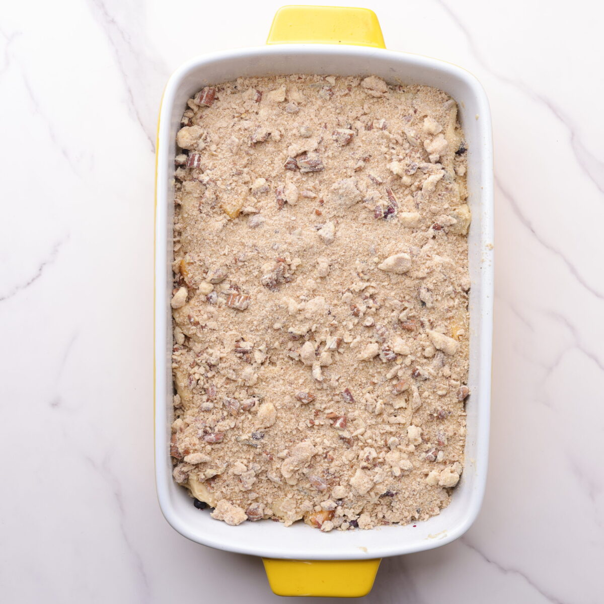 A 9x13 baking dish with the Peach and Blueberry Coffee cake fully assembled, ready to bake in it. 