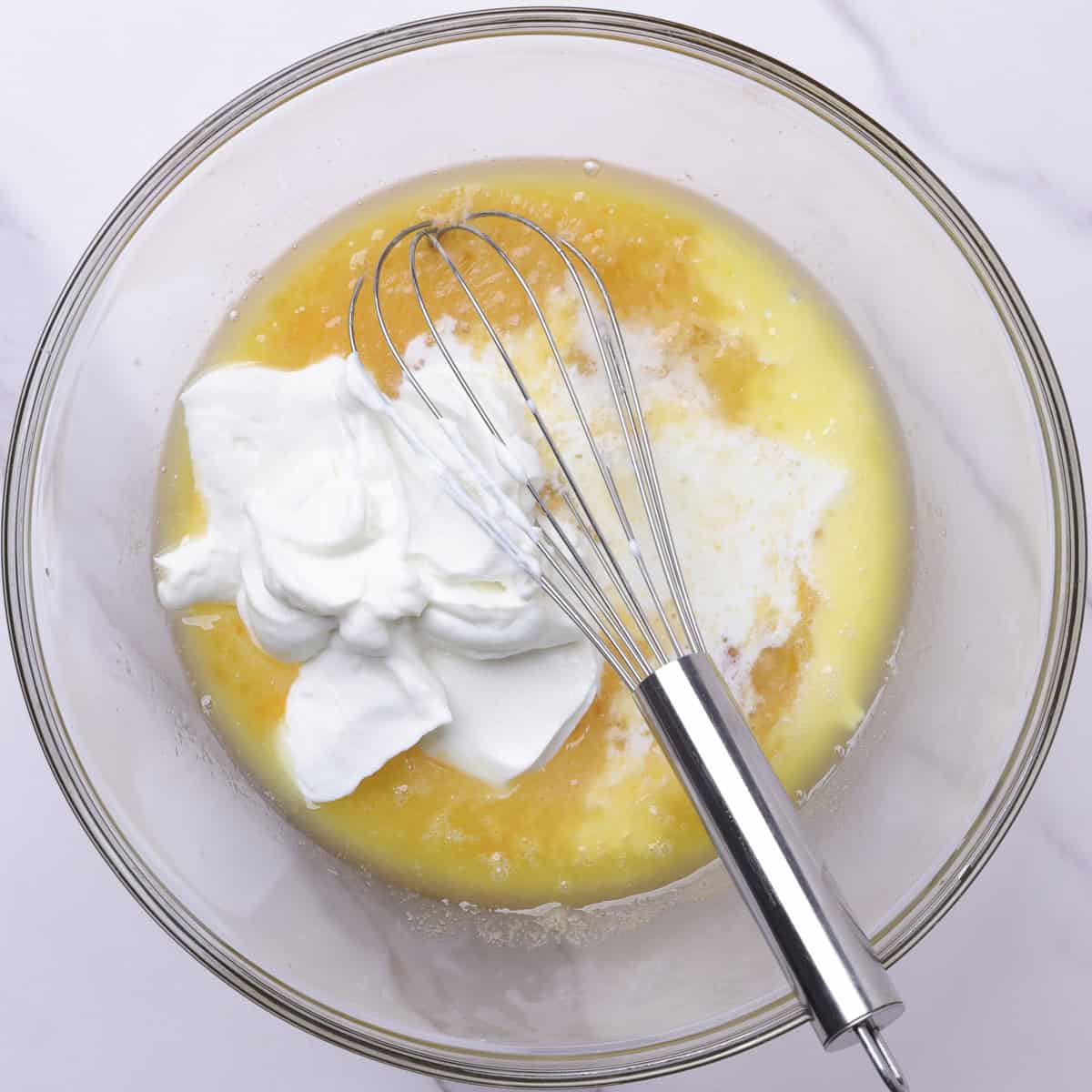 A glass bowl containing the wet ingredients.