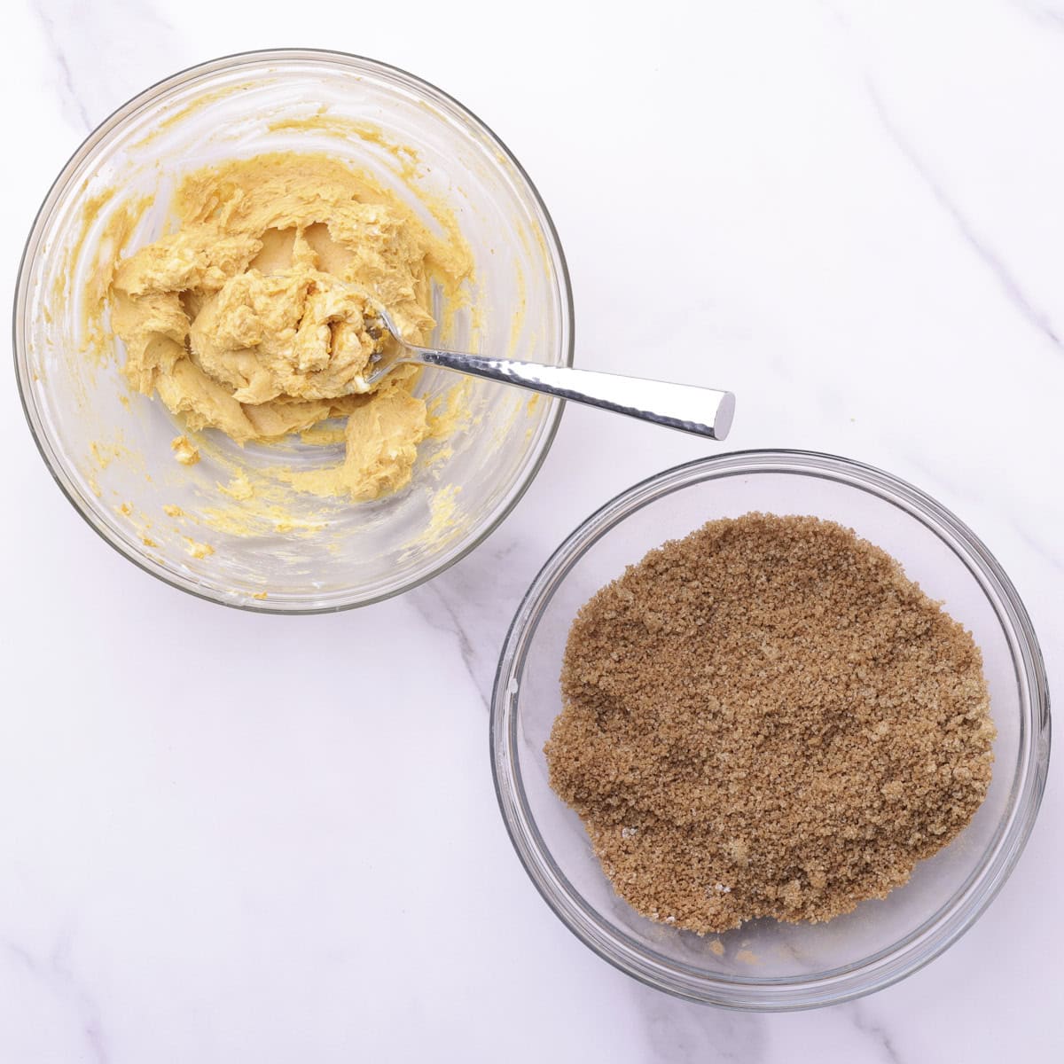 Two glass bowls, one with pumpkin butter and a spoon and the other with the spiced sugar mixture.