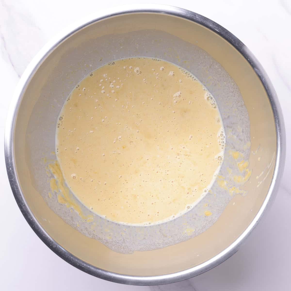 A mixing bowl with the wet ingredients in it.