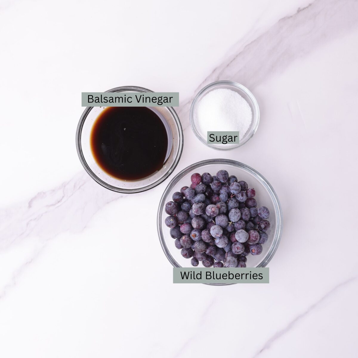 A visual display of the ingredients - balsamic vinegar, blueberries and sugar - each in their own bowl.