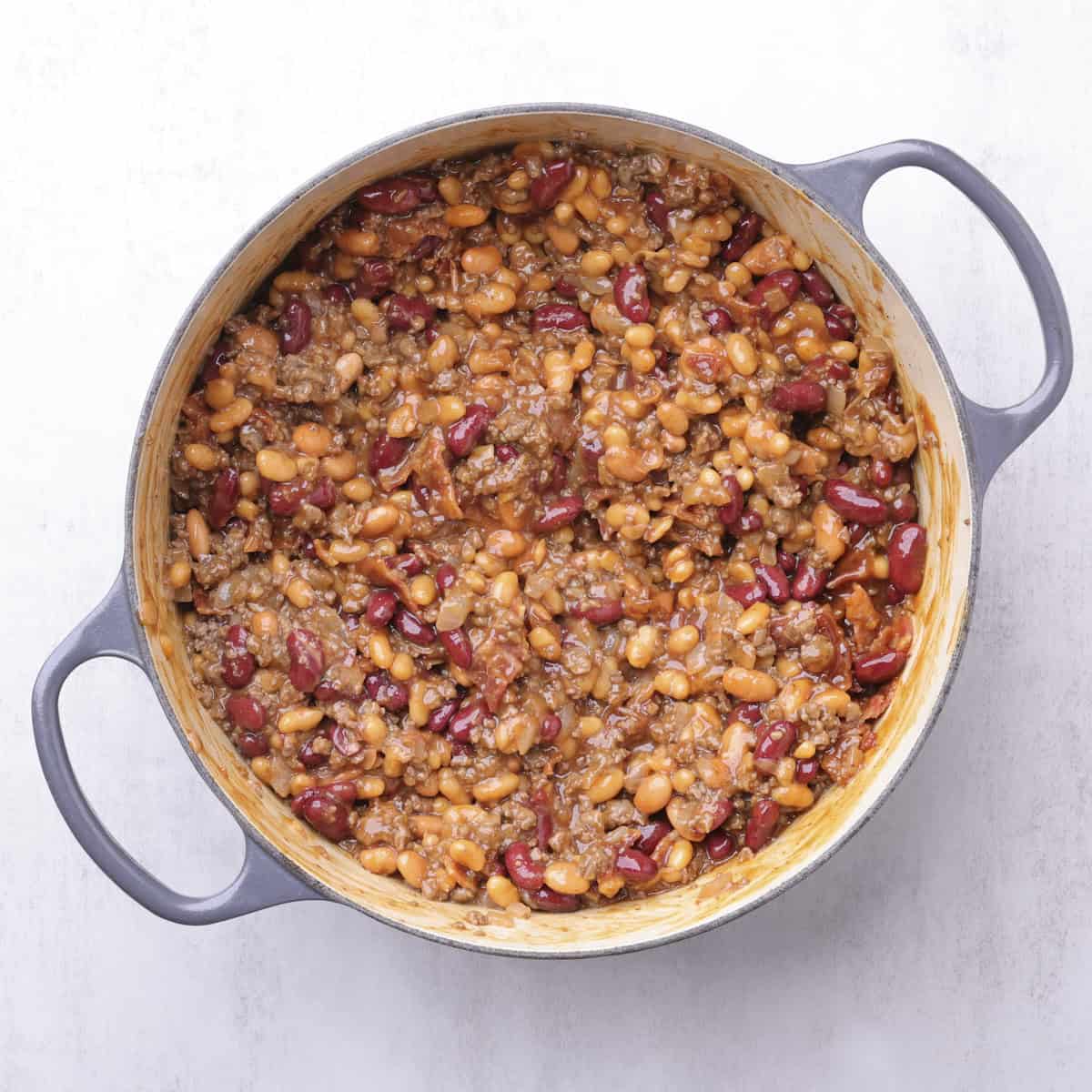 A cast iron pot with all the ingredients for the recipe combined and ready to bake.