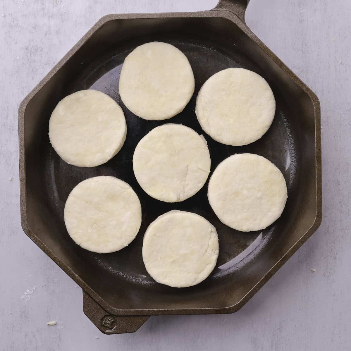 A skillet with the cut biscuits placed in it, ready to chill before baking.