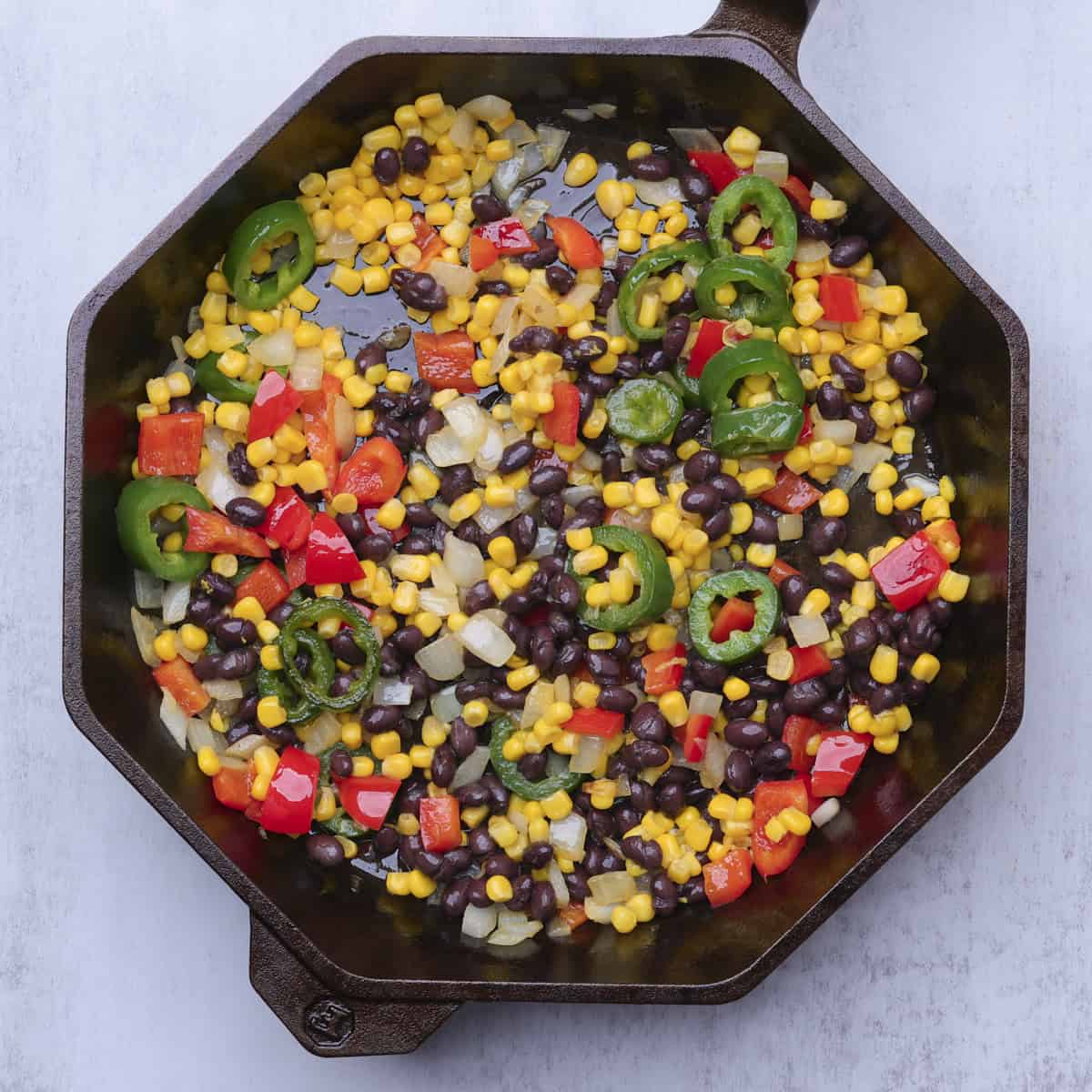 A skillet with all the vegetables sauteed in it.