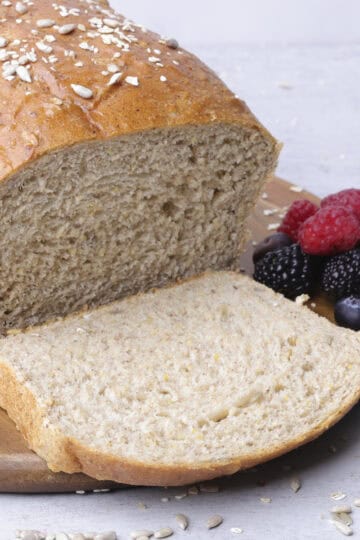 A sliced loaf of Seeded Bread displayed with berries.