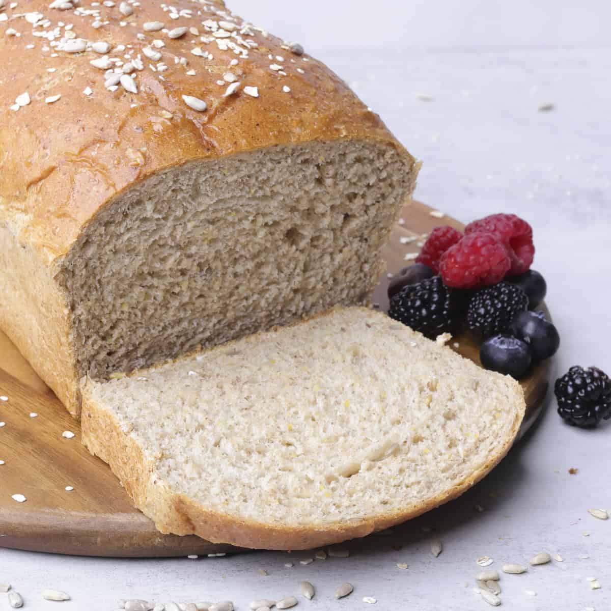 A sliced loaf of Seeded Bread displayed with berries.