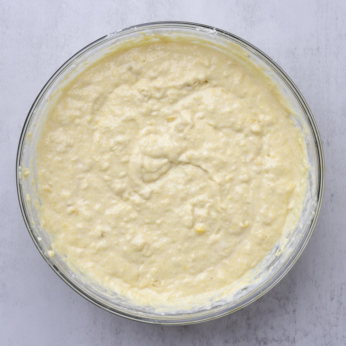 A glass bowl containing the finished batter for the Corn Bread.