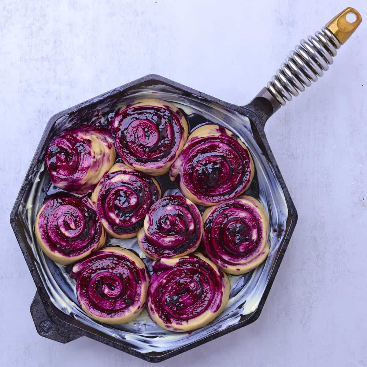 A skillet with the risen rolls, now filling the skillet.