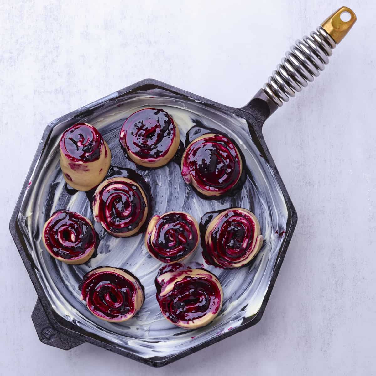 A buttered skillet with the formed rolls placed inside.