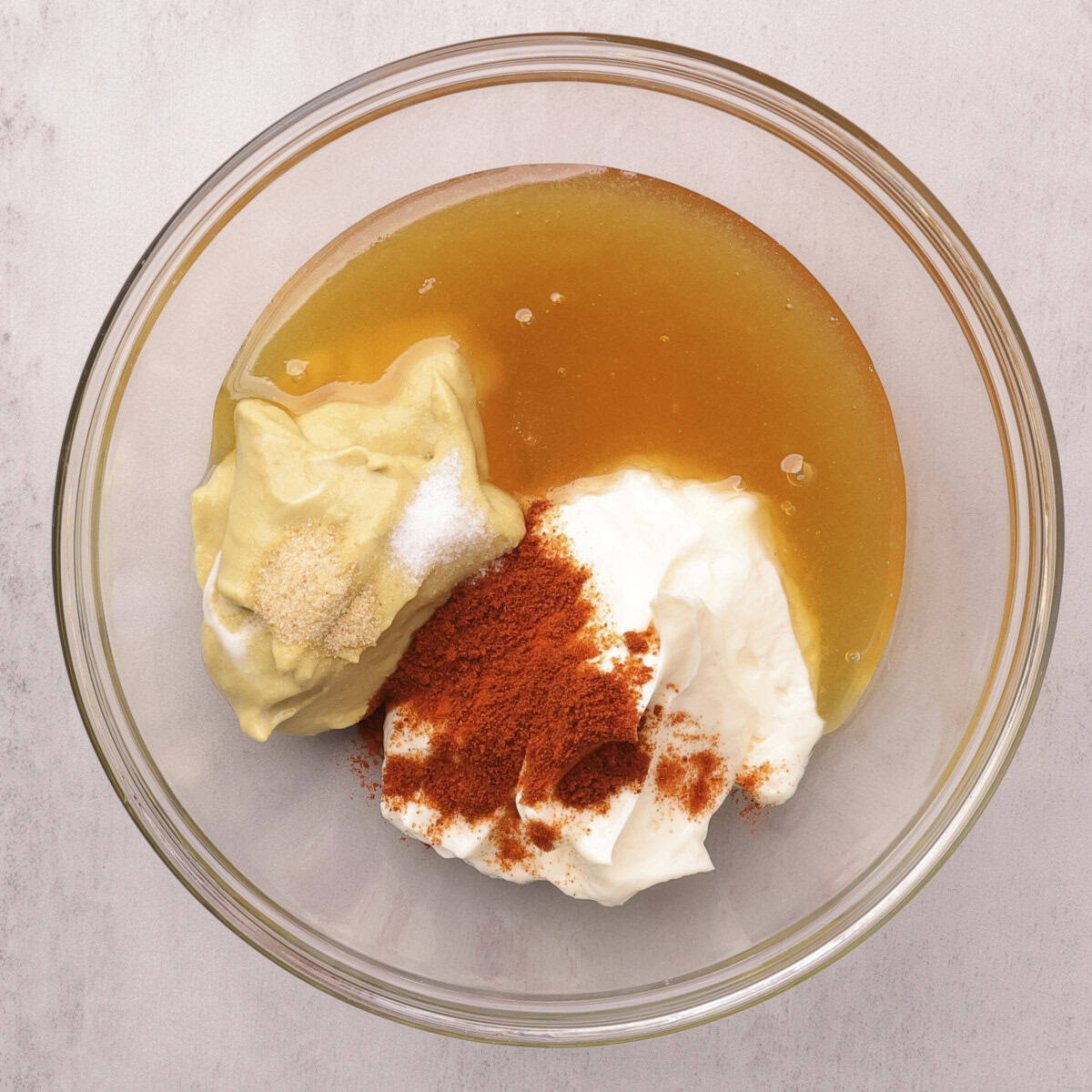 A bowl with all the ingredients for the Honey Mayo Mustard Sauce in it, ready to be combined.