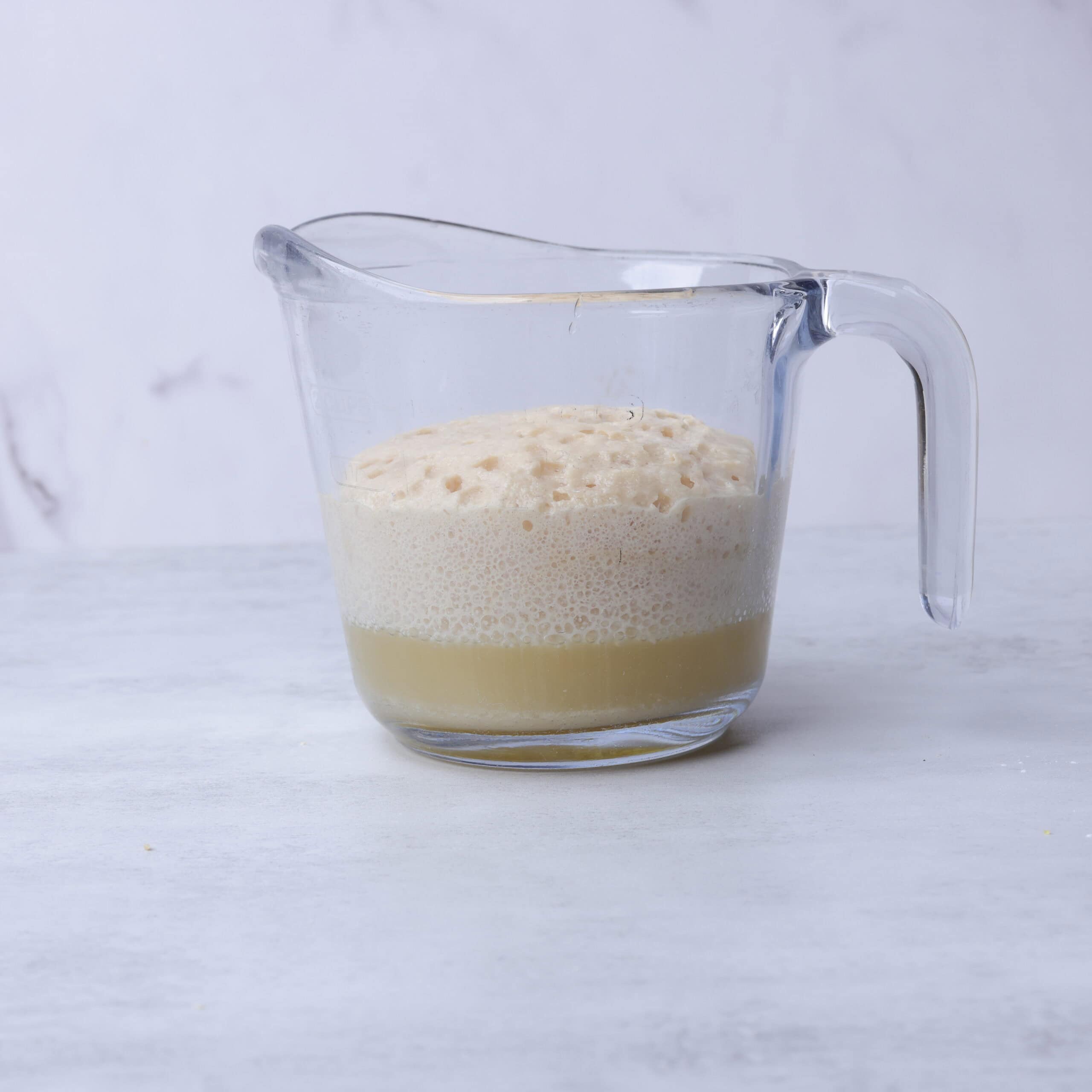 A glass measuring cup with the activated yeast mixture.