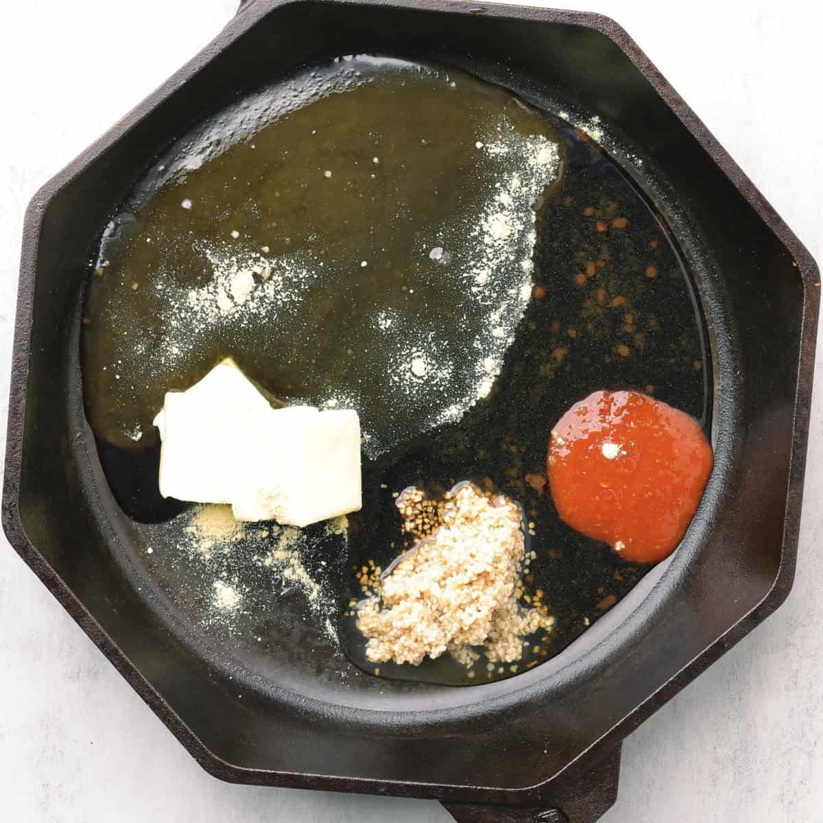 A skillet with the ingredients needed for the sauce to make the Sticky Chicken Drumsticks.