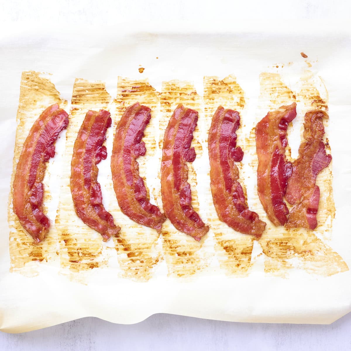 A cookie sheet with cooked slices of bacon.