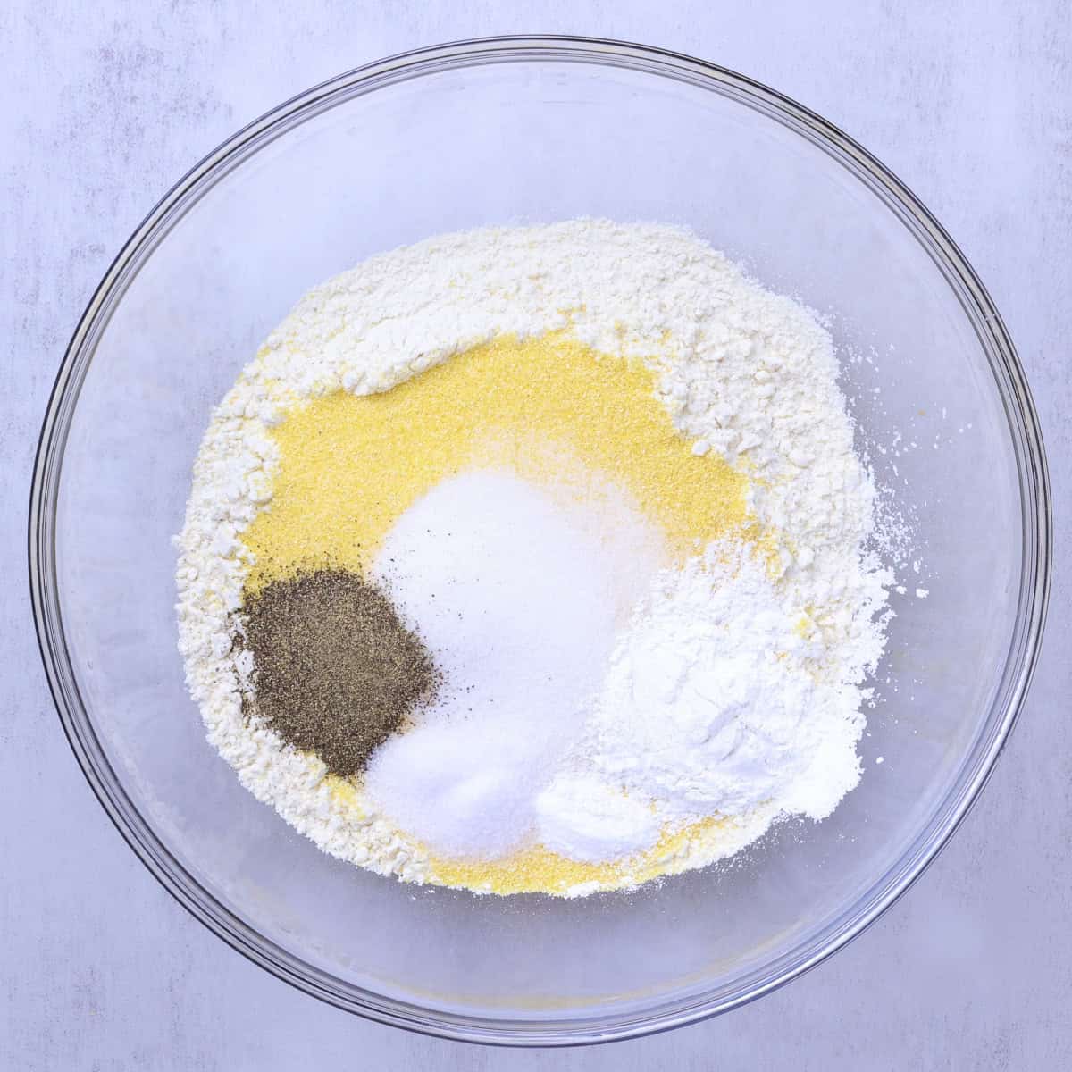 A bowl with the dry ingredients stacked on top of one another.