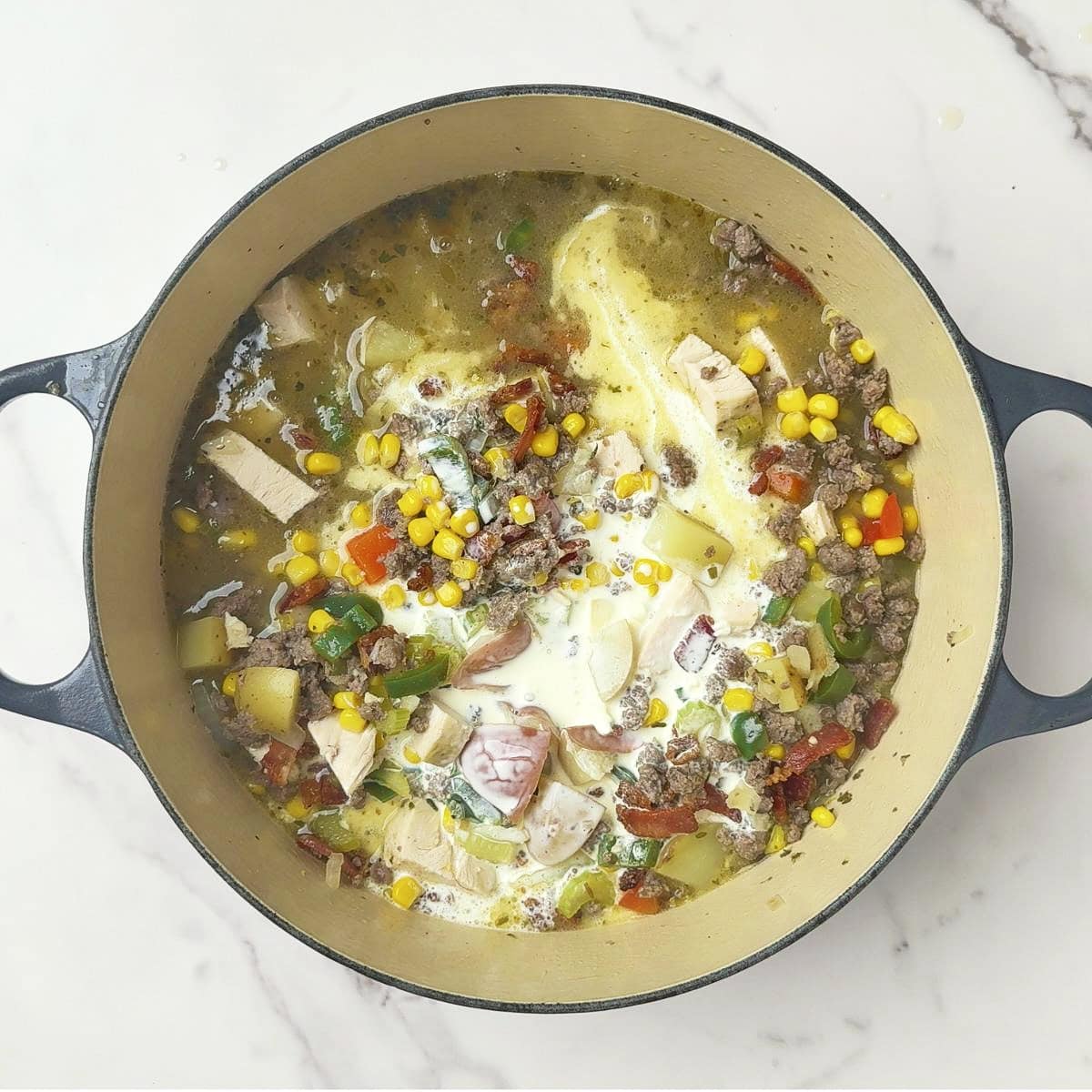 All of the ingredients added to the pot to create the Chicken and Sausage Soup.