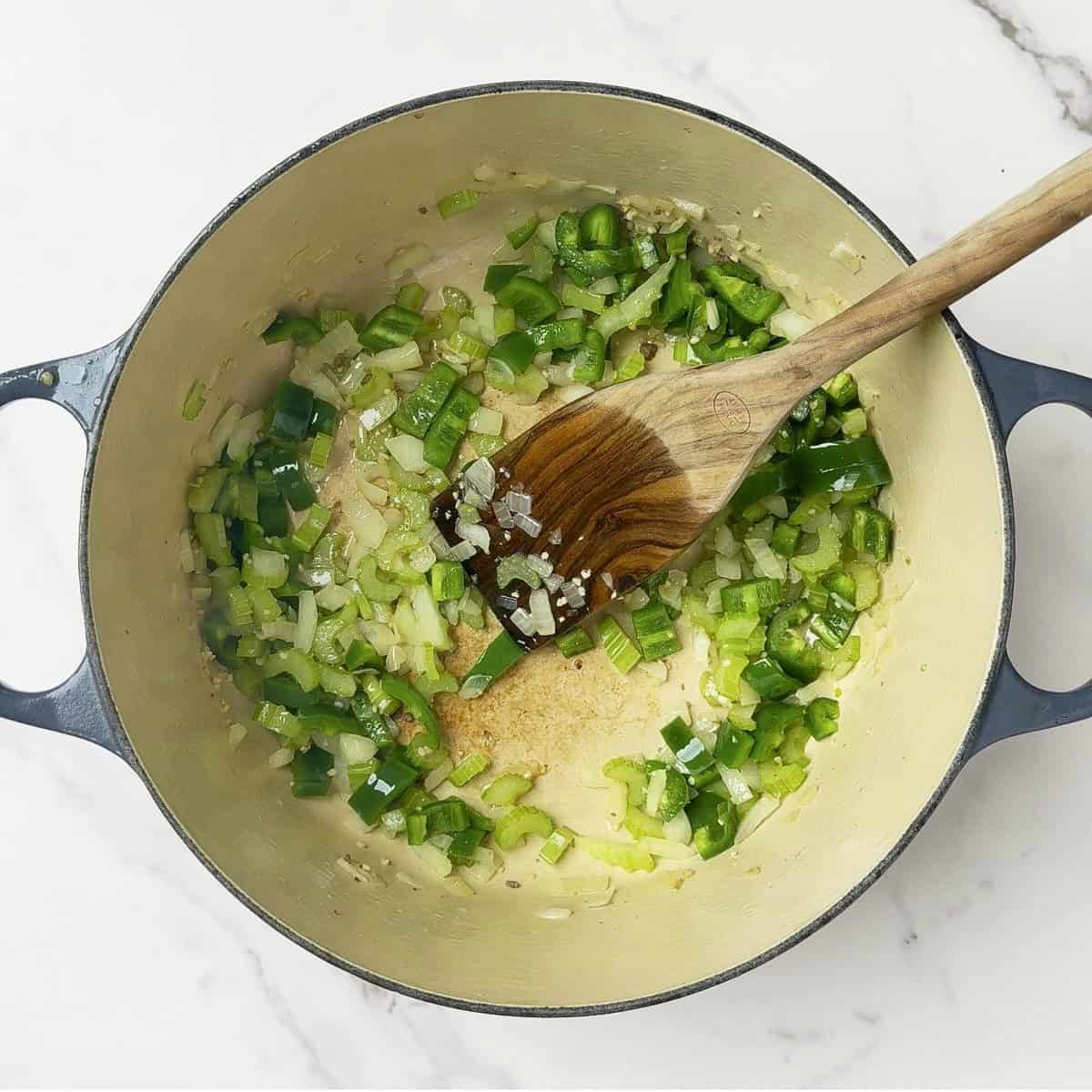 The jalapenos and minced garlic added to the celery and onions in the pot.