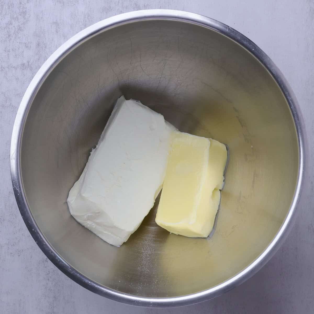 A mixing bowl with the butter and cream cheese in it.