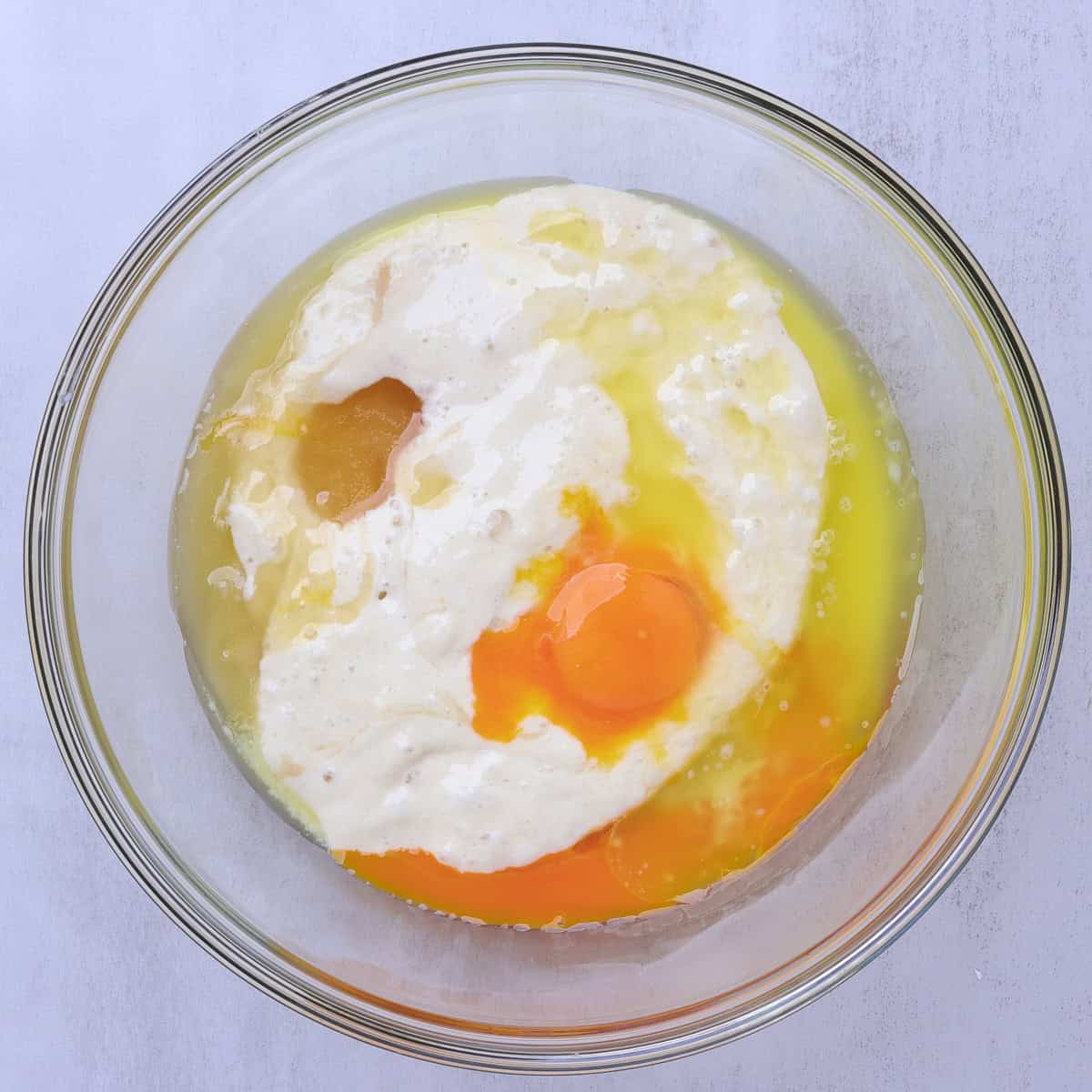 A glass bowl containing the wet ingredients for the pancakes. 