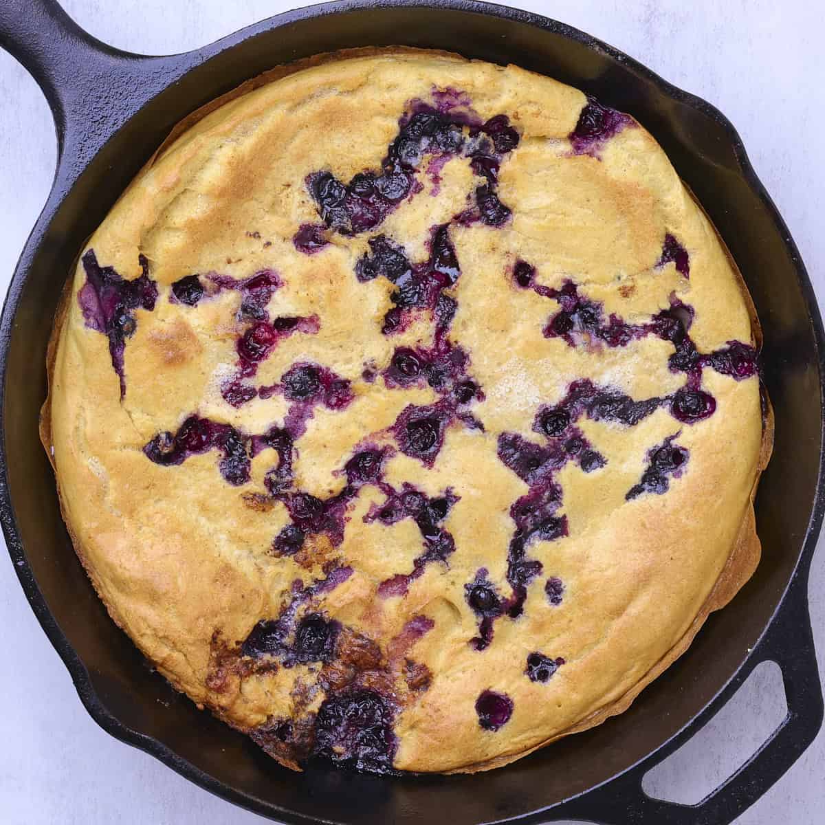 A golden brown, baked Sourdough German Pancake in a skillet.