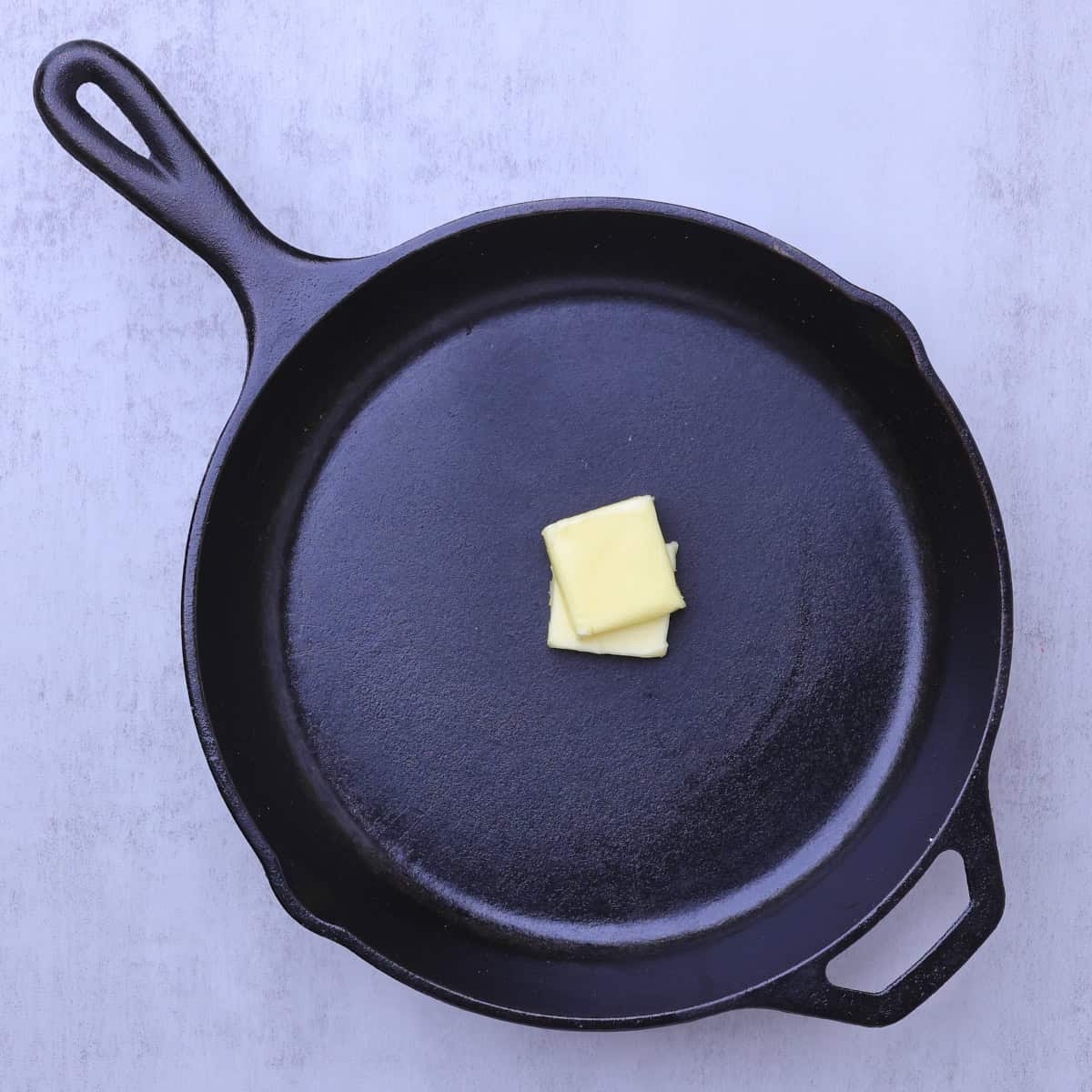 A skillet with 2 tablespoons of butter in it.