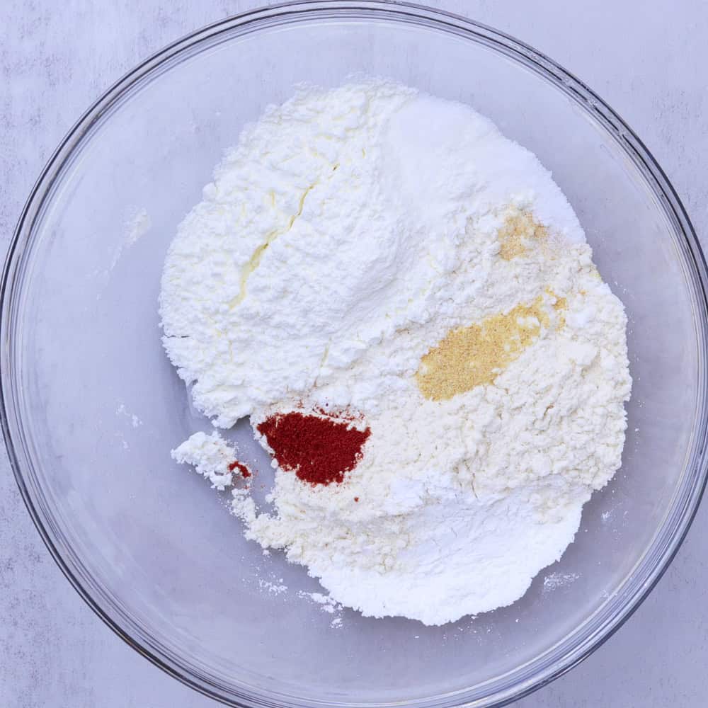 A glass bowl with all the dry ingredients in it.