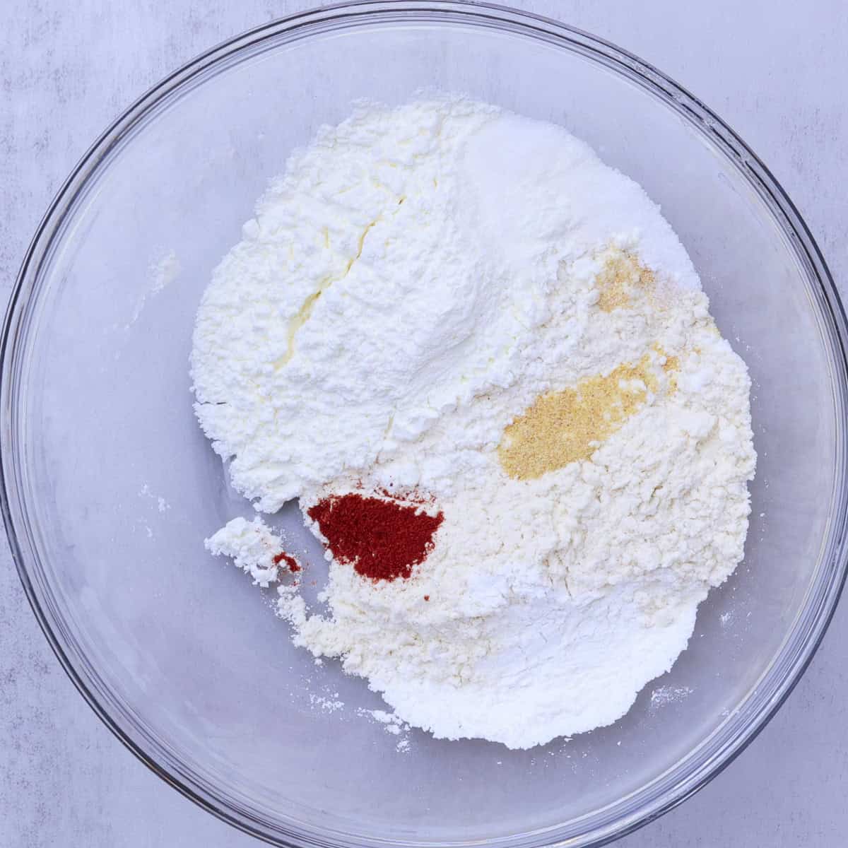 A glass bowl with all the dry ingredients in it.