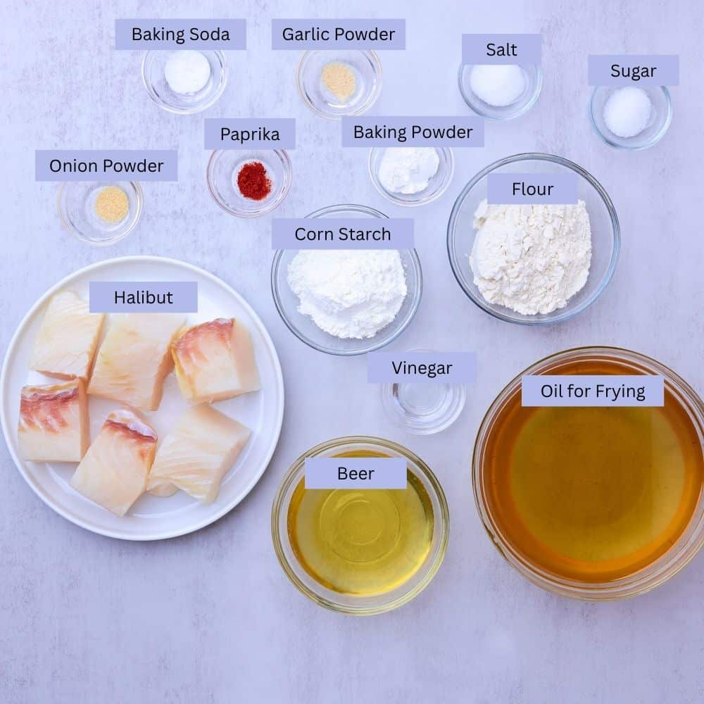 A visual display of the ingredients needed for Beer Battered Halibut - onion powder, paprika, garlic powder, salt, sugar, baking soda, baking powder, corn starch, flour, vinegar, beer, oil for frying and halibut - each displayed in their own bowl.