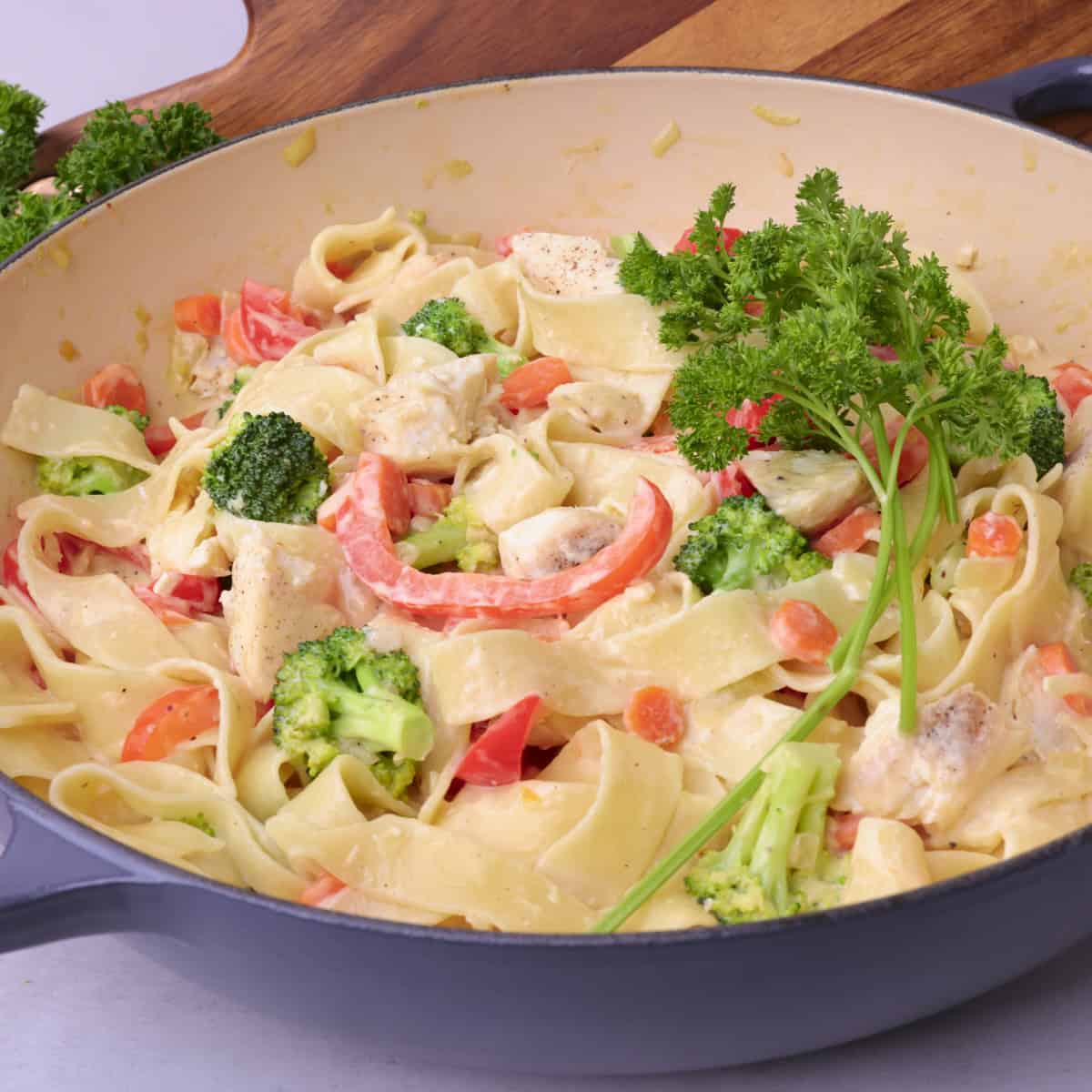 A pot of Halibut pasta topped with greens.