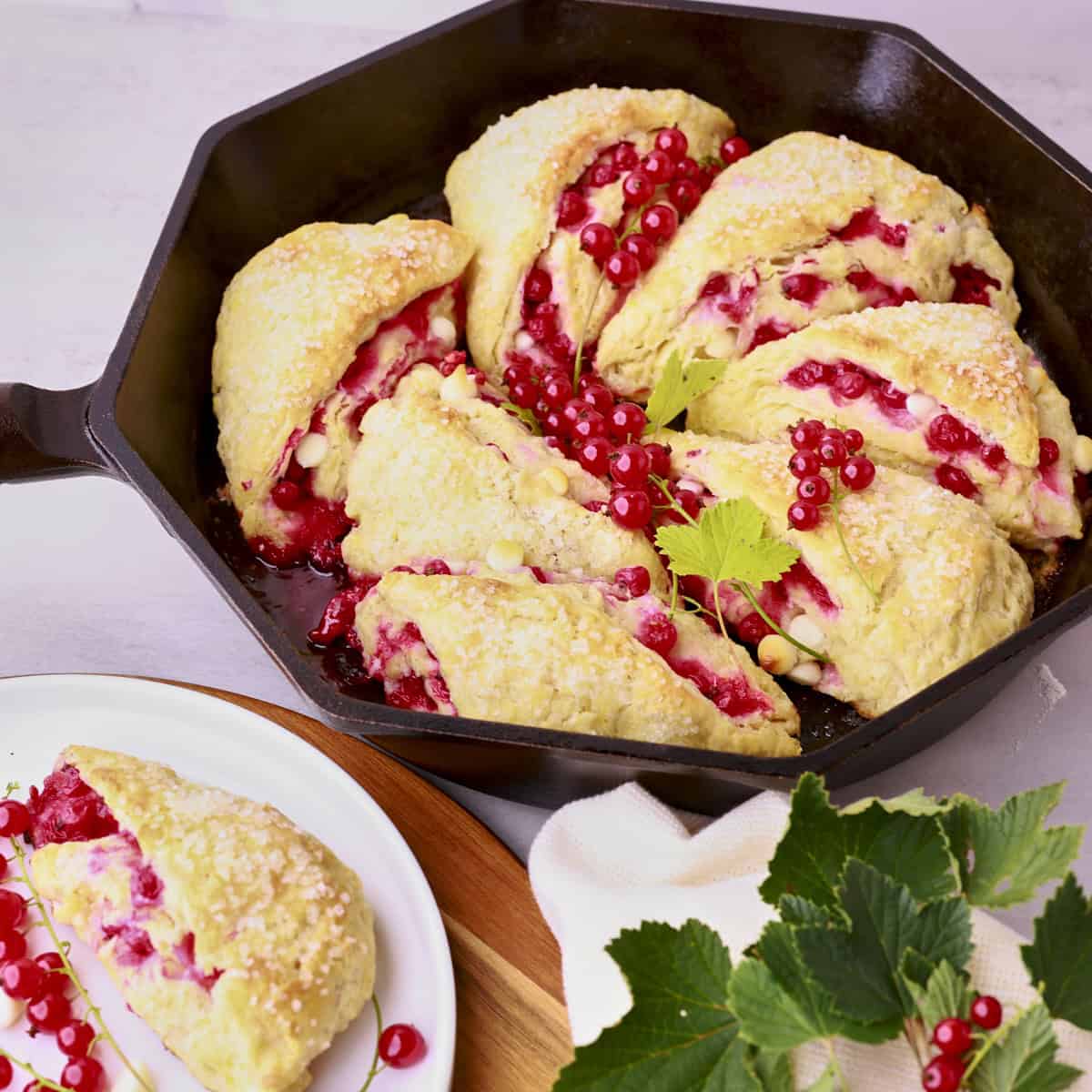 A skillet with the baked scones displayed with greens.