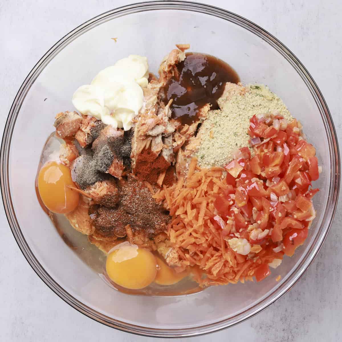 A glass bowl containing all of the ingredients needed for the salmon loaf.