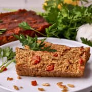 Slices of the salmon loaf on a white plate garnished with greens.