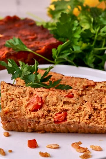 Slices of the salmon loaf on a white plate garnished with greens.