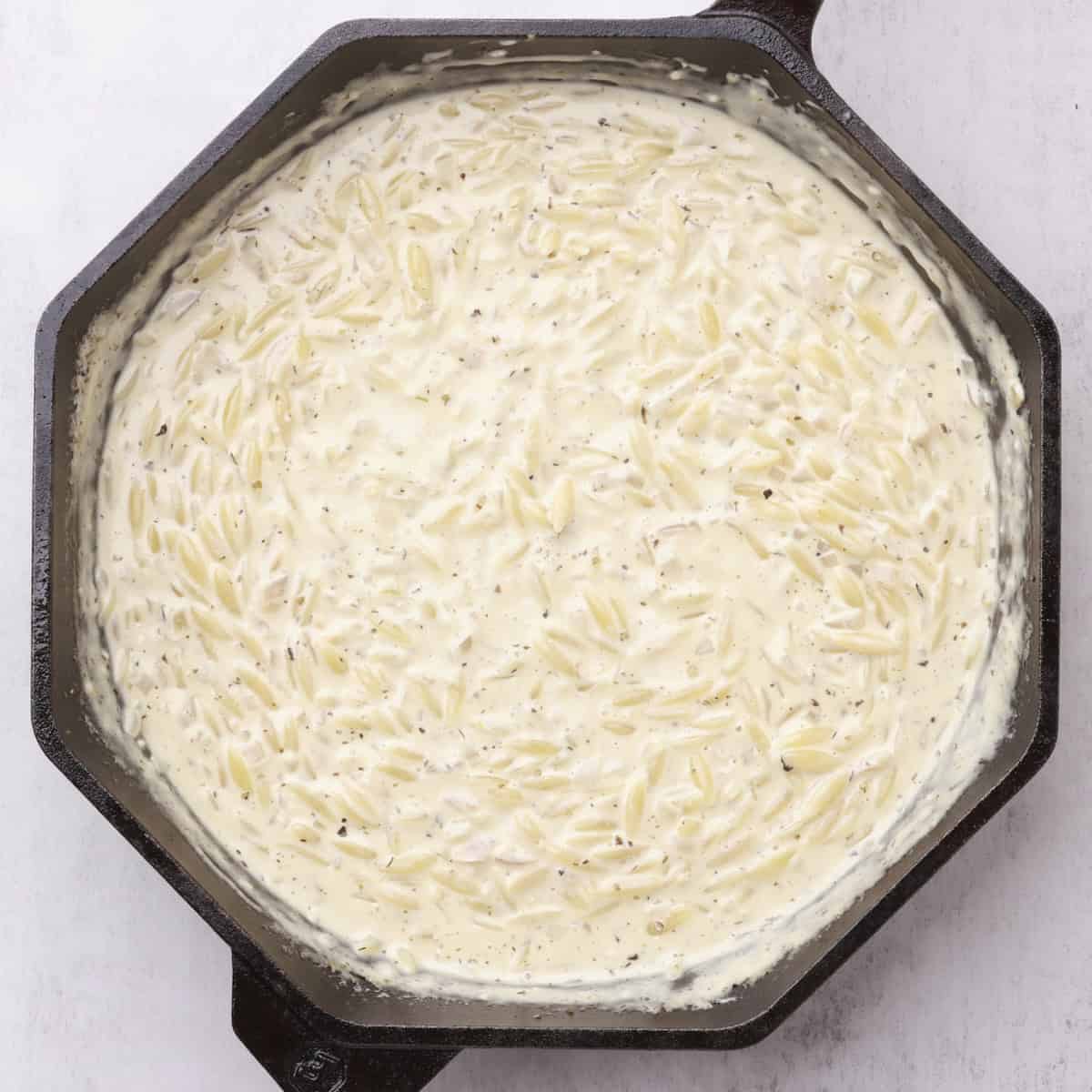 A skillet with the cooked orzo pasta.