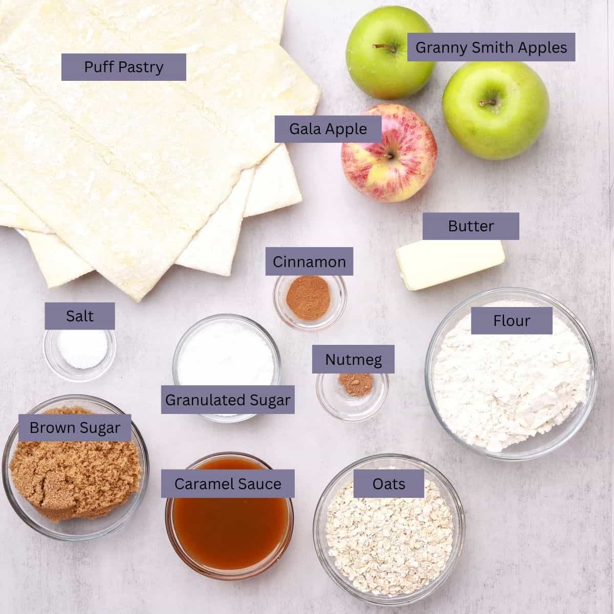 A visual display of the ingredients needed for the Apple Pie with Crumb Topping - puff pastry, apples, butter, cinnamon, nutmeg, salt, sugar, flour, oats, caramel sauce and brown sugar. 